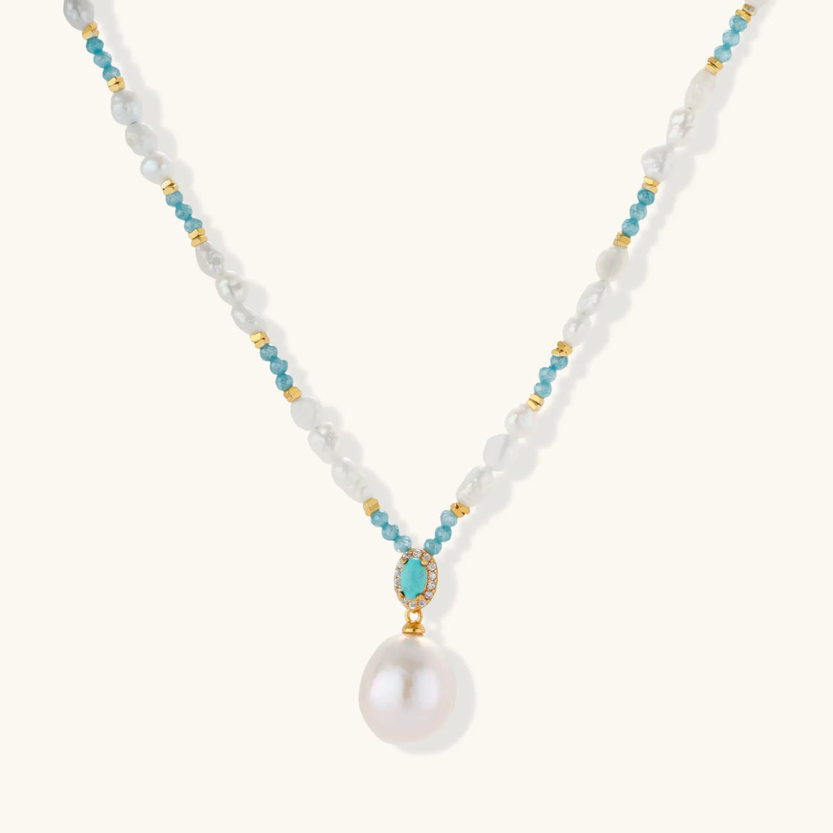 Beaded necklace with baroque pearls, turquoise stones and gold accents featuring a large pearl pendant.