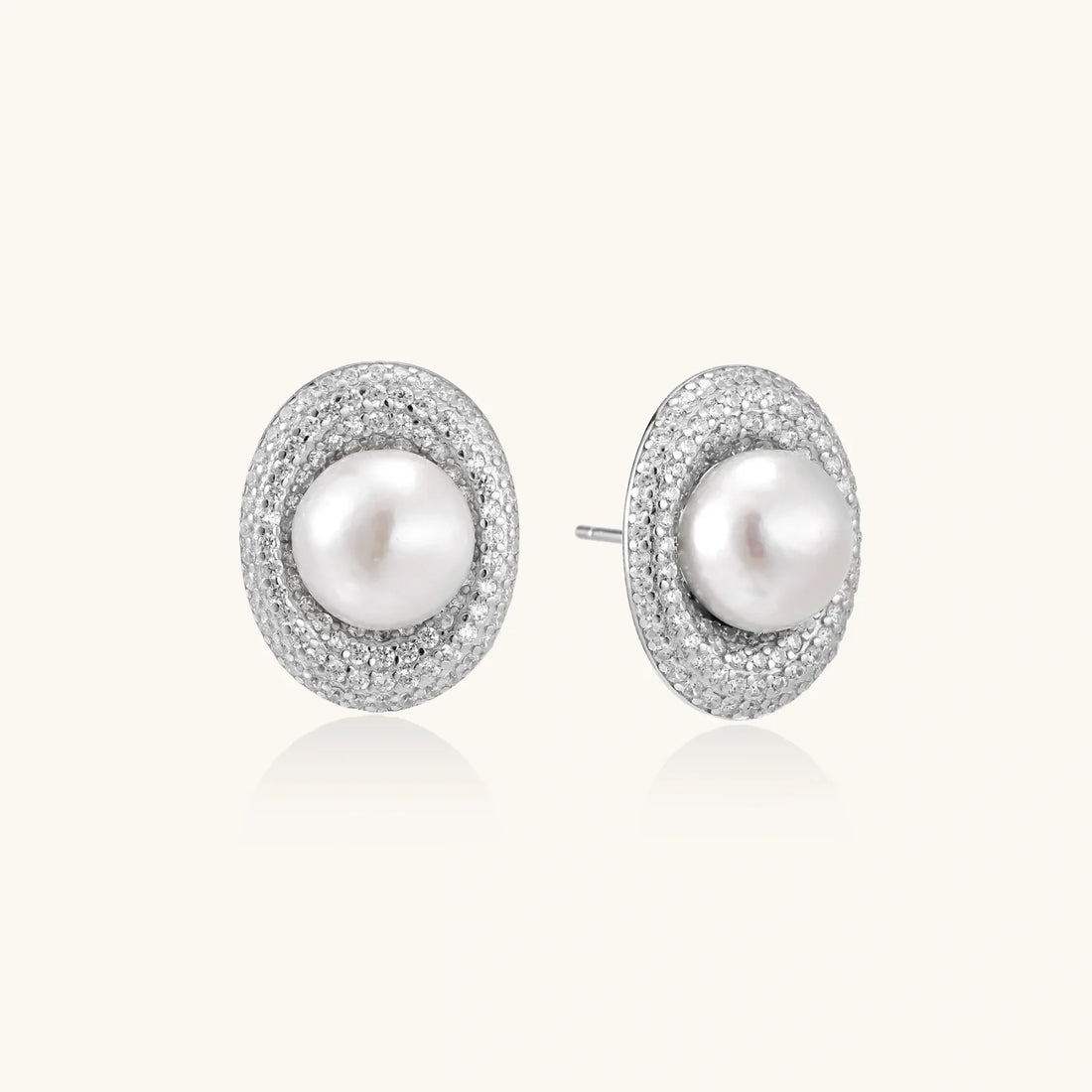 Stud earrings with cream freshwater pearls surrounded by pavé crystals on rhodium-plated silver setting.