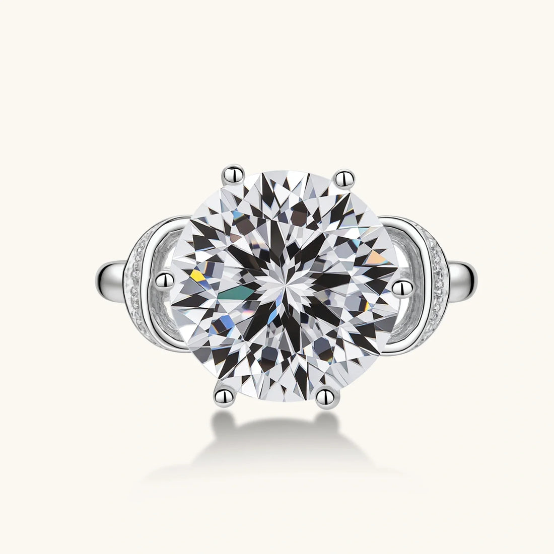 Sterling silver ring with a 5ct round moissanite centre stone and intricate bow design with pavé accents.