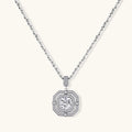 Sterling silver octagonal pendant necklace with brilliant moissanite center stone and halo setting on white background.