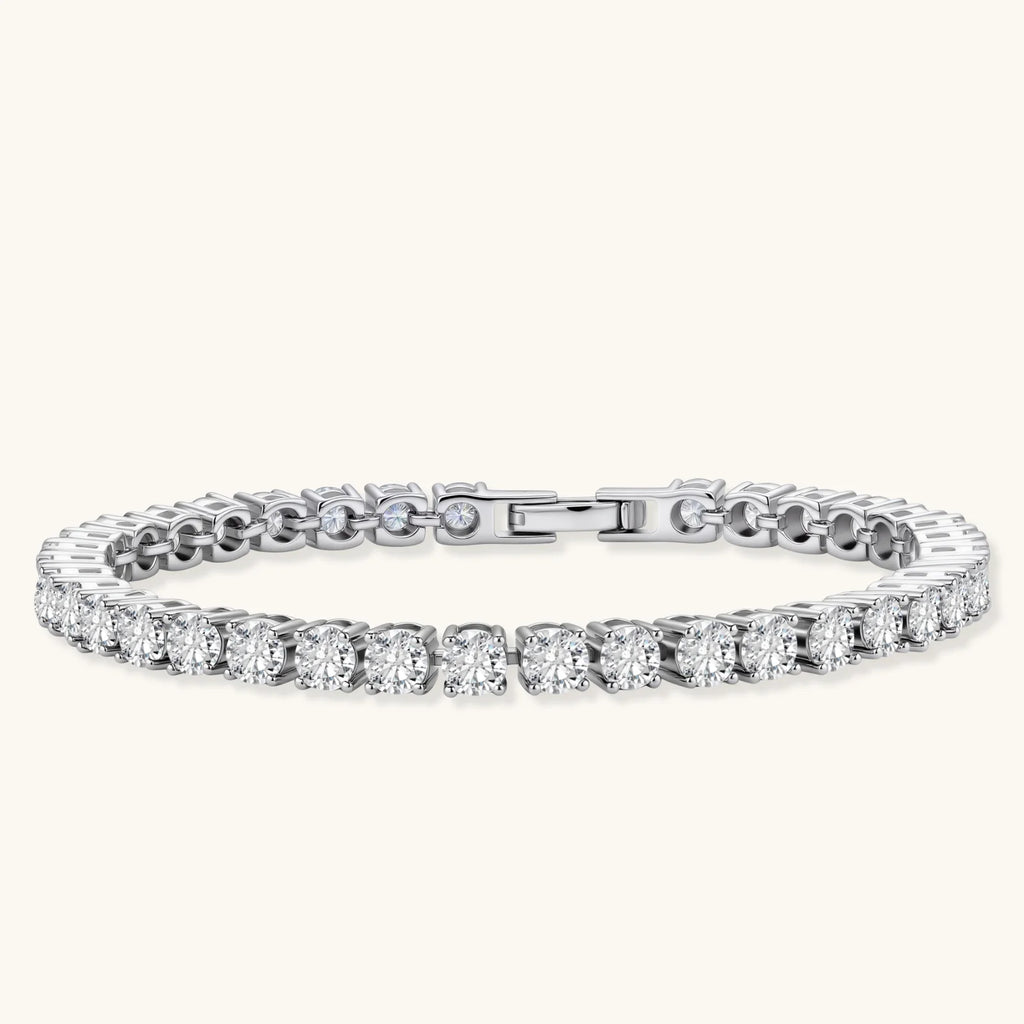 Sterling silver tennis bracelet with continuous row of brilliant moissanite stones and secure clasp closure on cream background.
