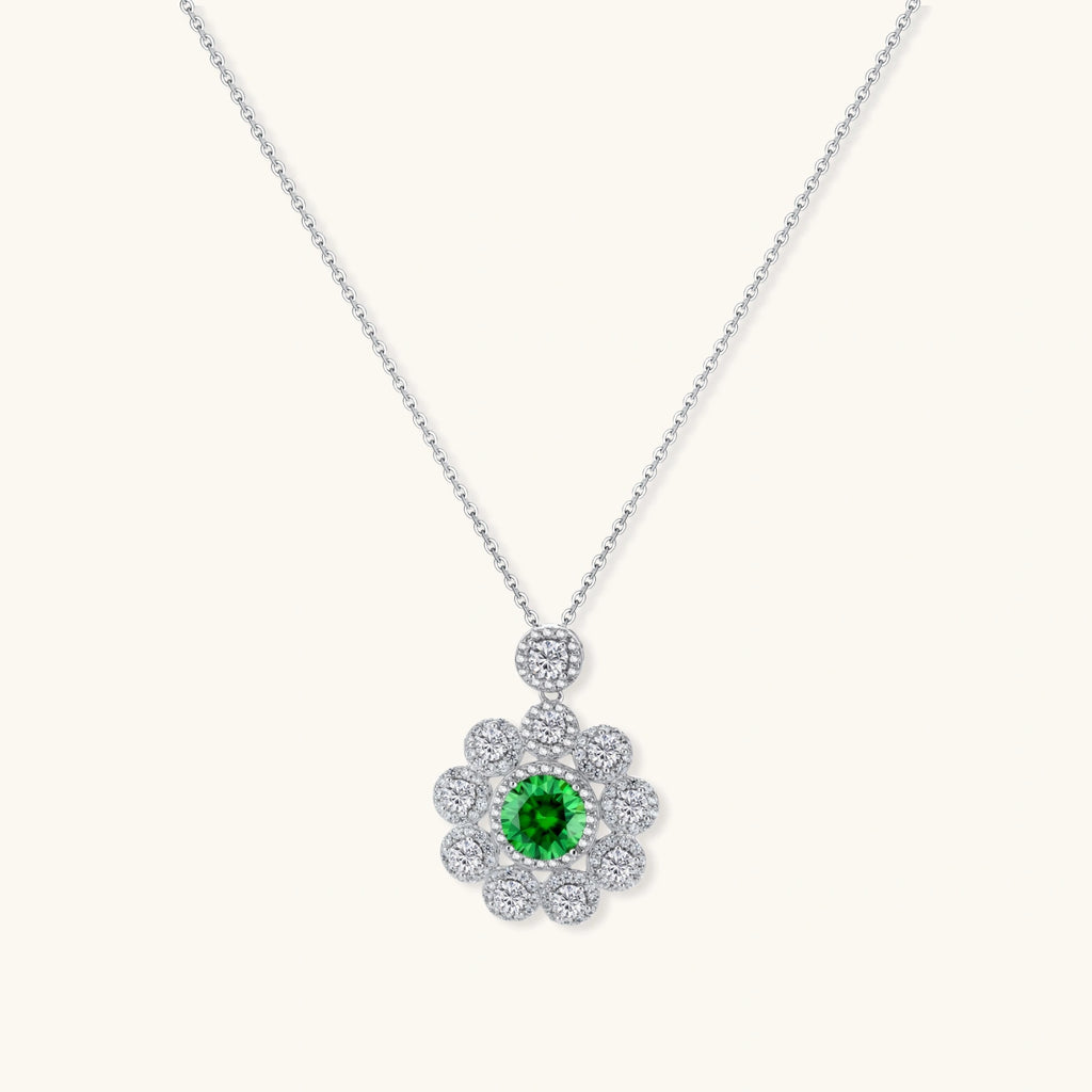 Delicate sterling silver necklace with flower-shaped pendant featuring bright green center moissanite and clear accent stones