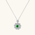 Delicate sterling silver necklace with flower-shaped pendant featuring bright green center moissanite and clear accent stones