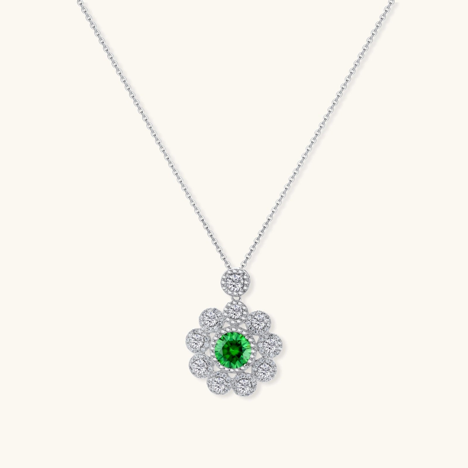Delicate sterling silver necklace with flower-shaped pendant featuring bright green center moissanite and clear accent stones