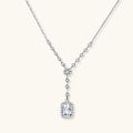 Sterling silver Y-necklace with rectangular moissanite pendant in halo setting and cascading accent stones on white background.